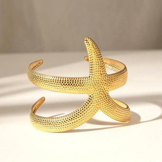 Close-up of sculptural gold starfish cuff bracelet with textured finish