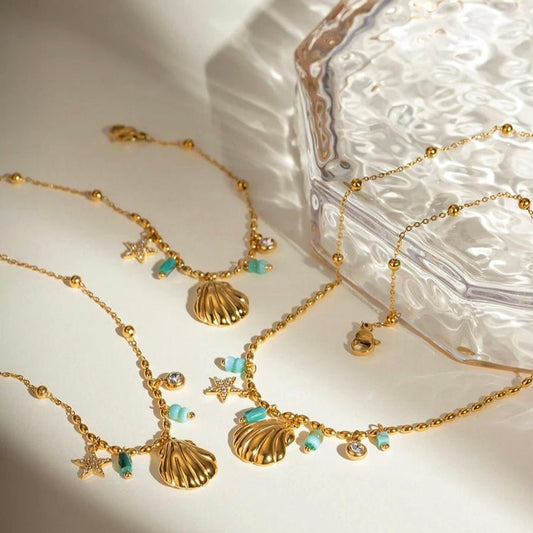 Gold charm jewelry set with ring, bracelet and necklace featuring turquoise beads and shell pendants