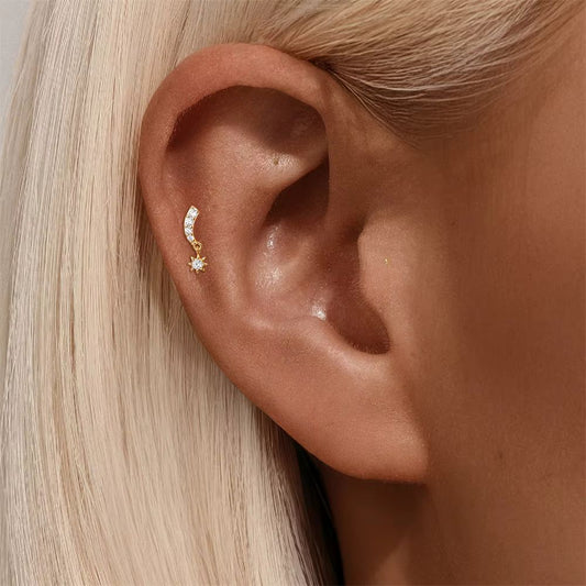 Celeste Curve gold cartilage stud worn on flat helix piercing with curved zirconia line and star charm