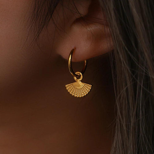 Model wearing gold fan pendant hoop earrings, elegant and minimalist jewelry