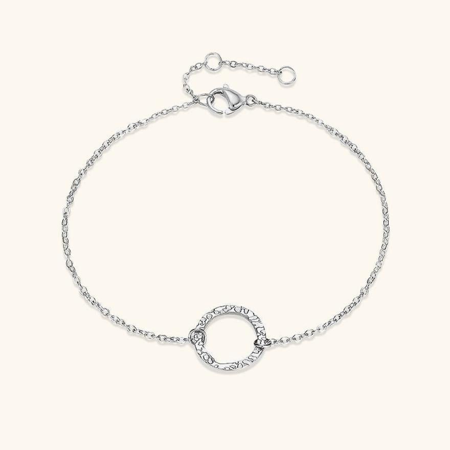 Delicate gold chain bracelet with a textured hoop centerpiece