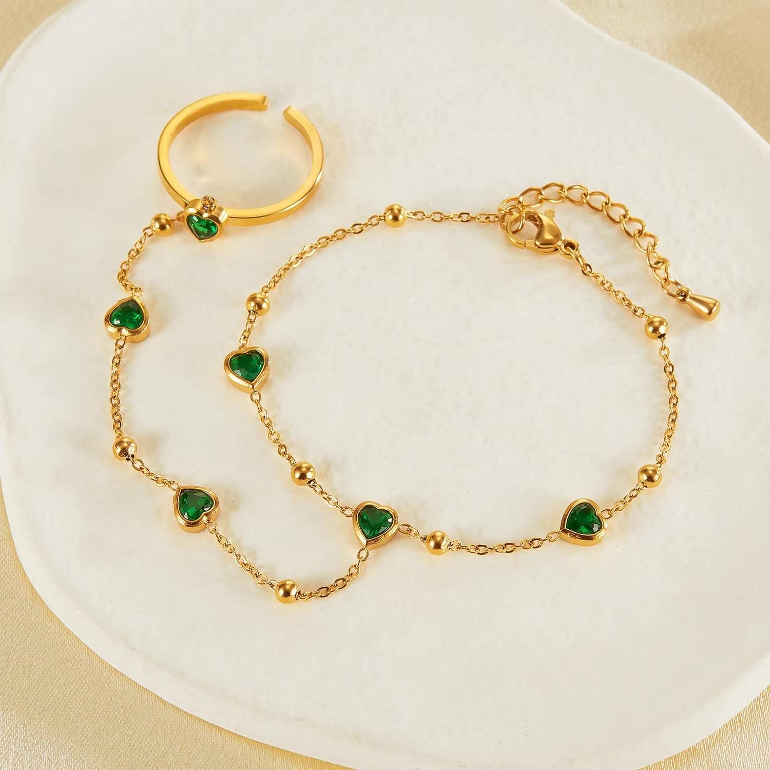 Gold hand chain with emerald hearts for elegant, standout styling