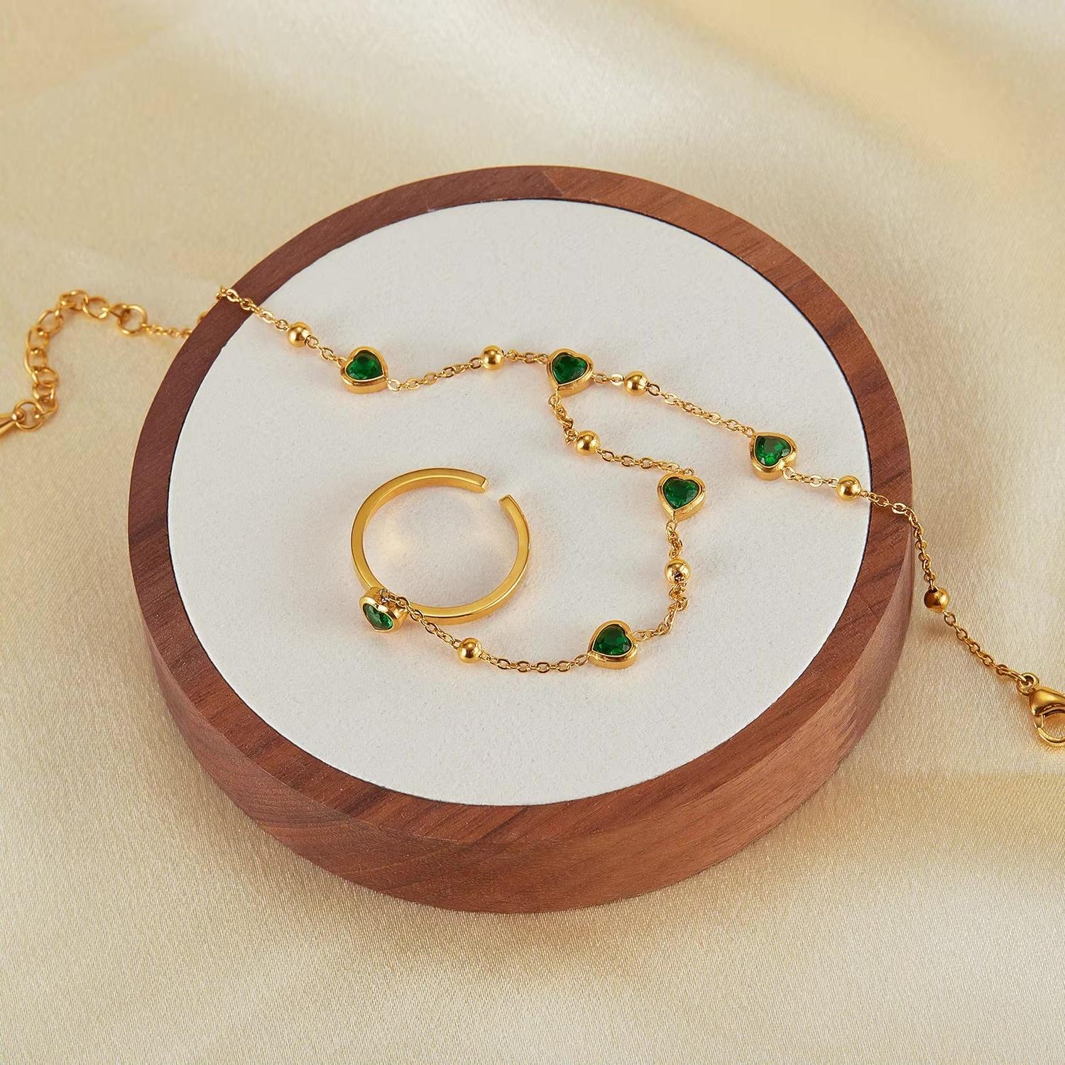 Gold hand chain with emerald hearts for elegant, standout styling