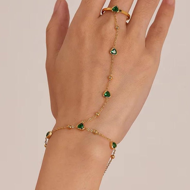 Gold hand chain with emerald hearts for elegant, standout styling