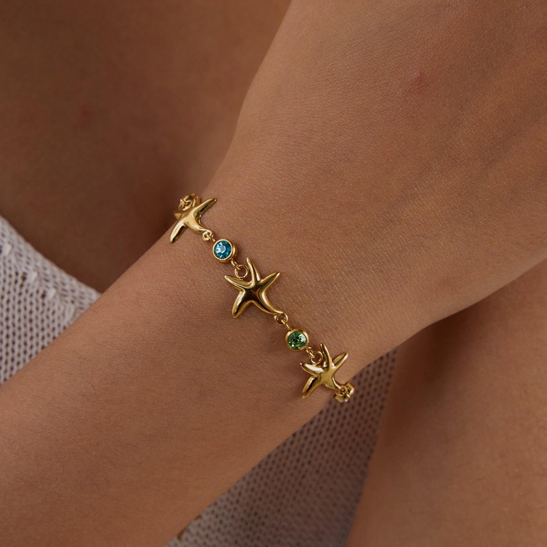 Ocean-inspired gold bracelet with colorful gems and starfish charms