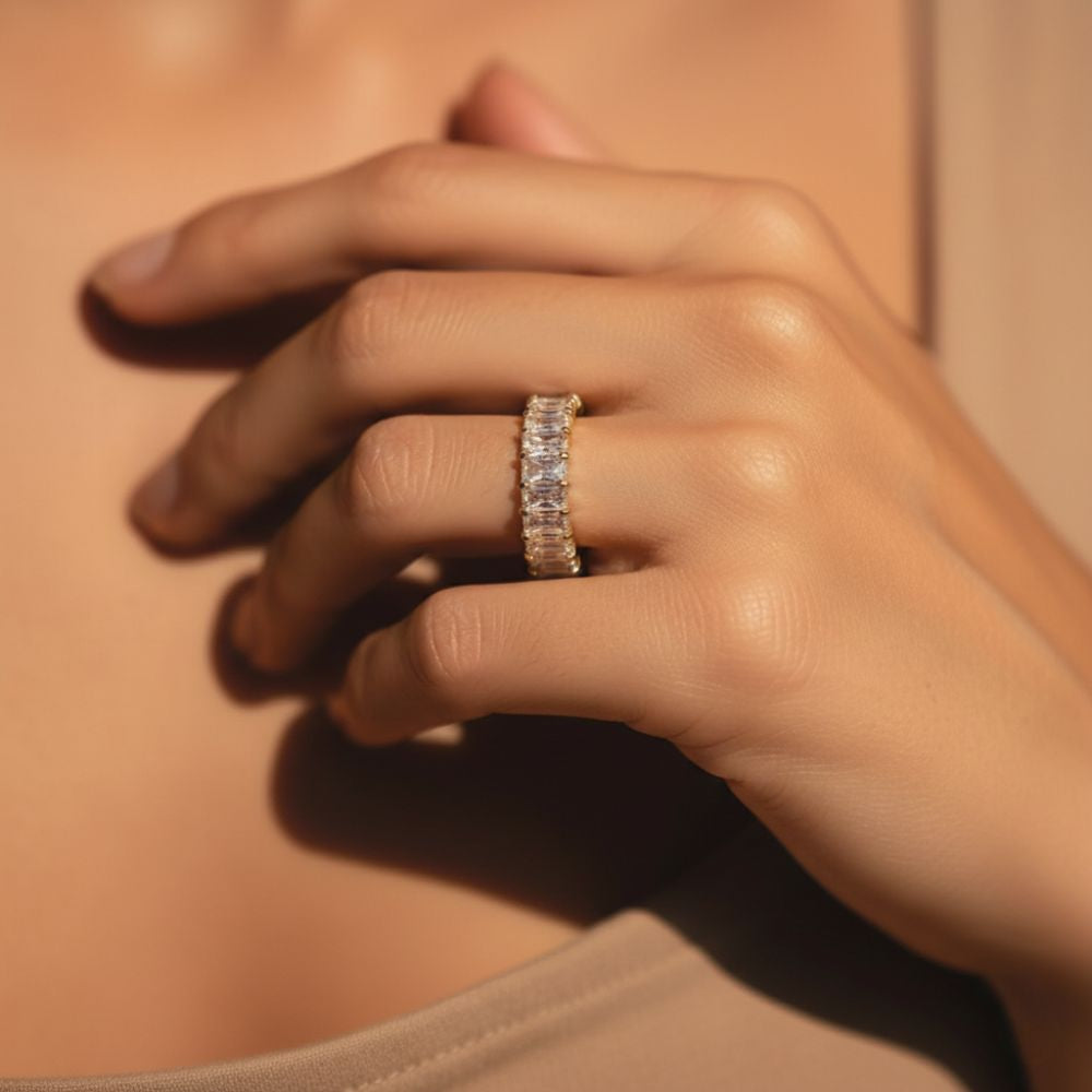 Astra Ring gold crystal baguette eternity band on warm beige background