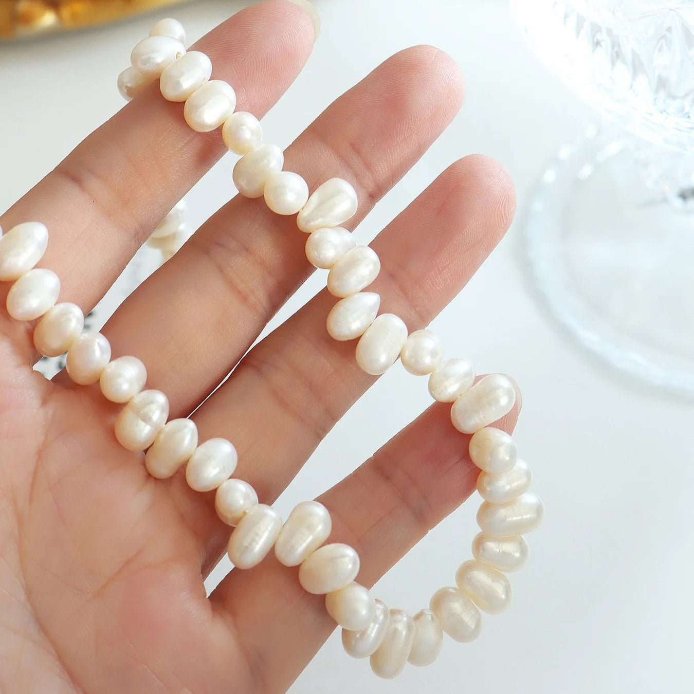 Close-up of the Baroque Pearl Choker held in hand against a white background.