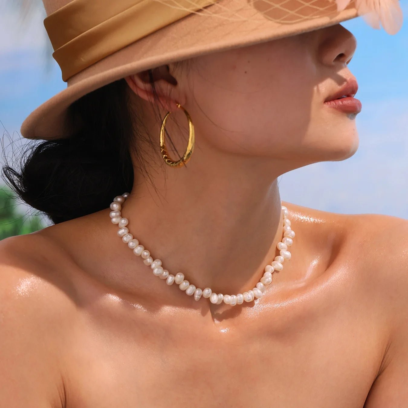  Baroque Pearl Choker worn with a straw sunhat and black strapless top, summer look.
