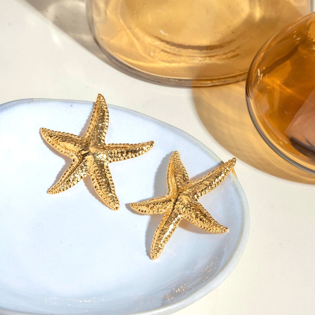 Woman wearing gold starfish earring, side profile view for summer jewelry inspiration