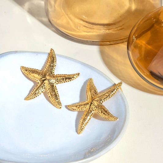 Beach-inspired starfish earrings displayed on ceramic plate