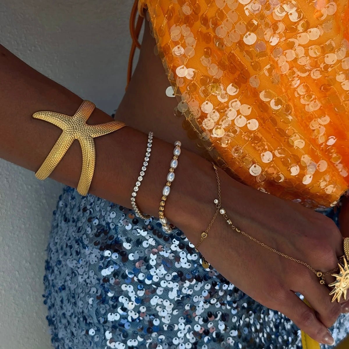 Statement starfish cuff bracelet worn with sequin outfit and summer accessories