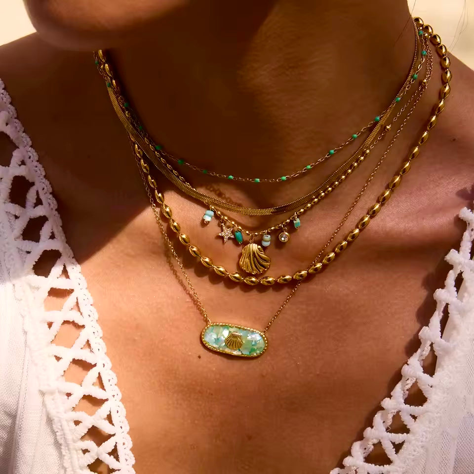 Front view of a colorful broken shell necklace in blue-green, pink and yellow tones, with a gold seashell charm.