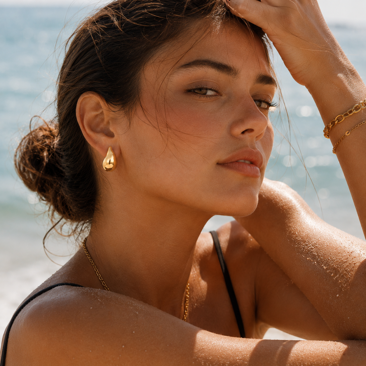 Chunky gold teardrop stud earrings on model, coastal style waterproof gold jewelry