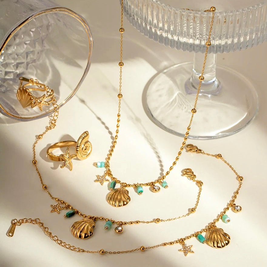 gold necklaces with shell and star charms, turquoise beads and crystal details