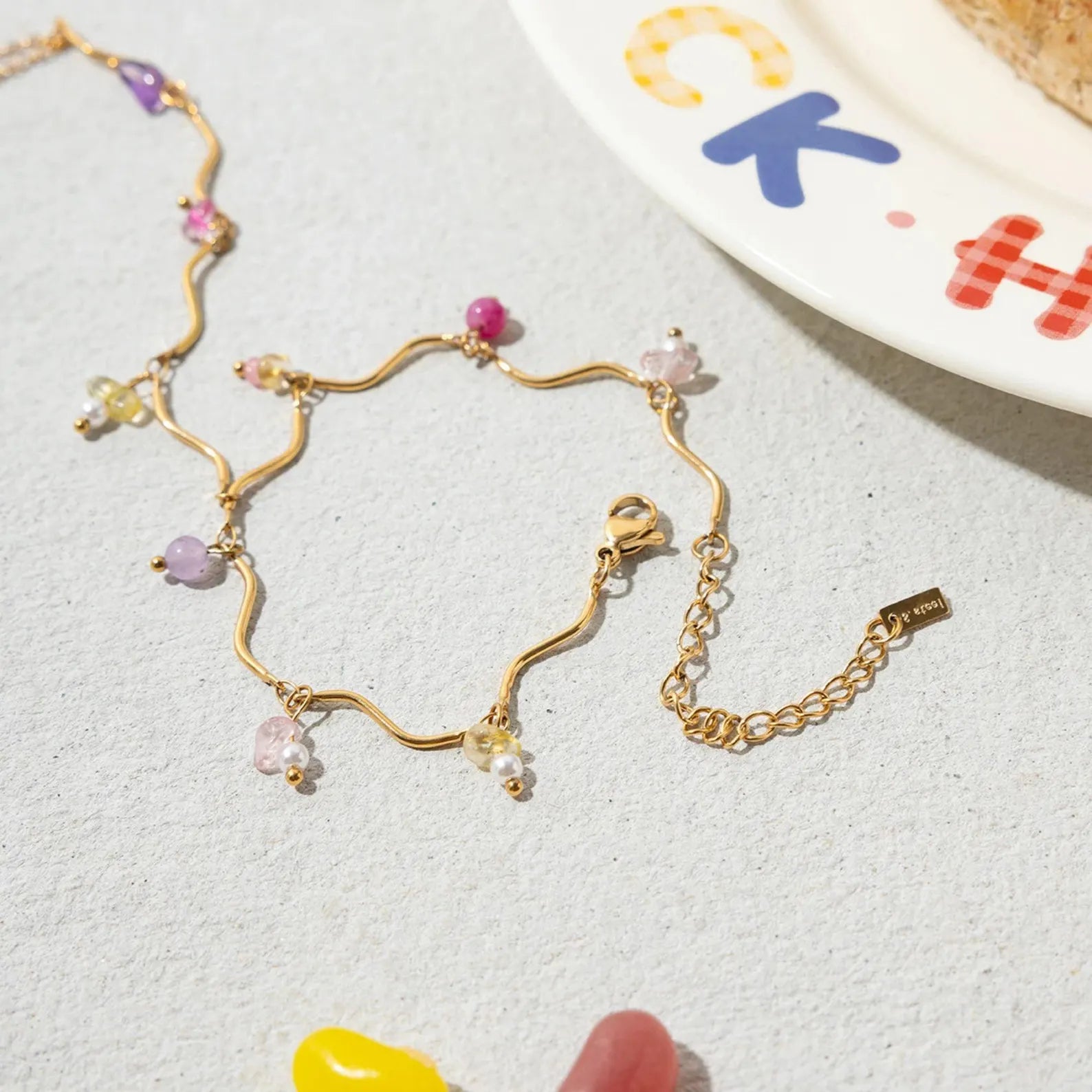 Detailed view of colorful beaded gold hand chain bracelet with extension chain
