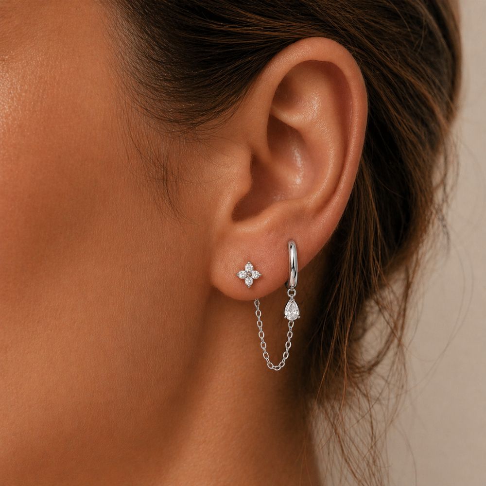 Silver double piercing chain earring worn on ear with CZ stud and hoop connected by chain