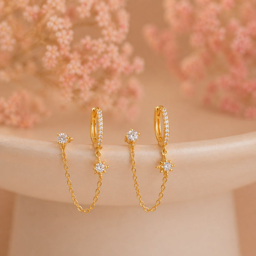 Gold double piercing chain pavé hoop earrings pair with CZ stud and north star charm on neutral background