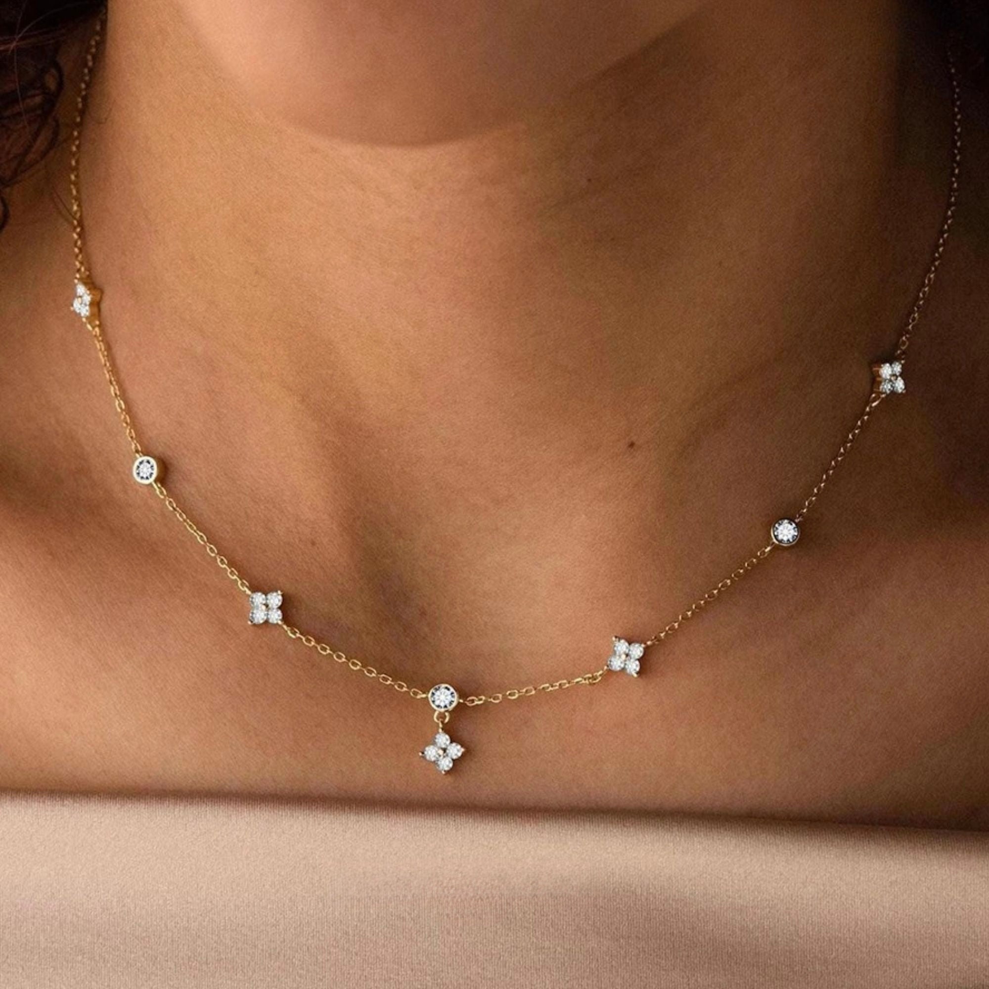 Close-up of gold daisy station necklace showing delicate zircon flower charms