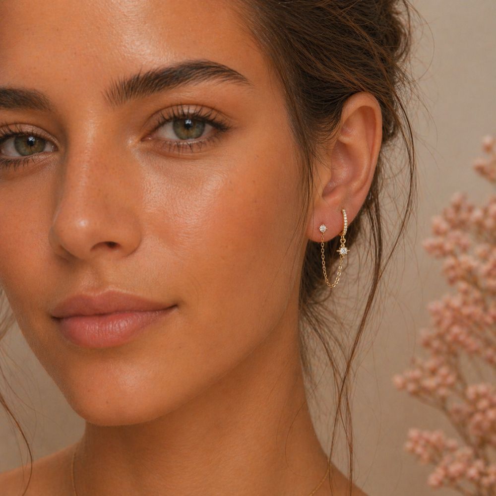 Gold double piercing chain earring with pavé hoop and north star charm worn on ear