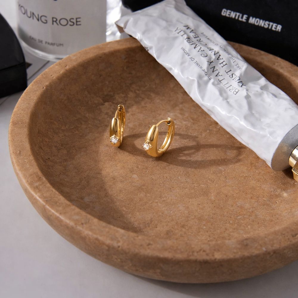 Gold huggie hoop earrings with white zircon on stone tray, minimalist stainless steel jewelry