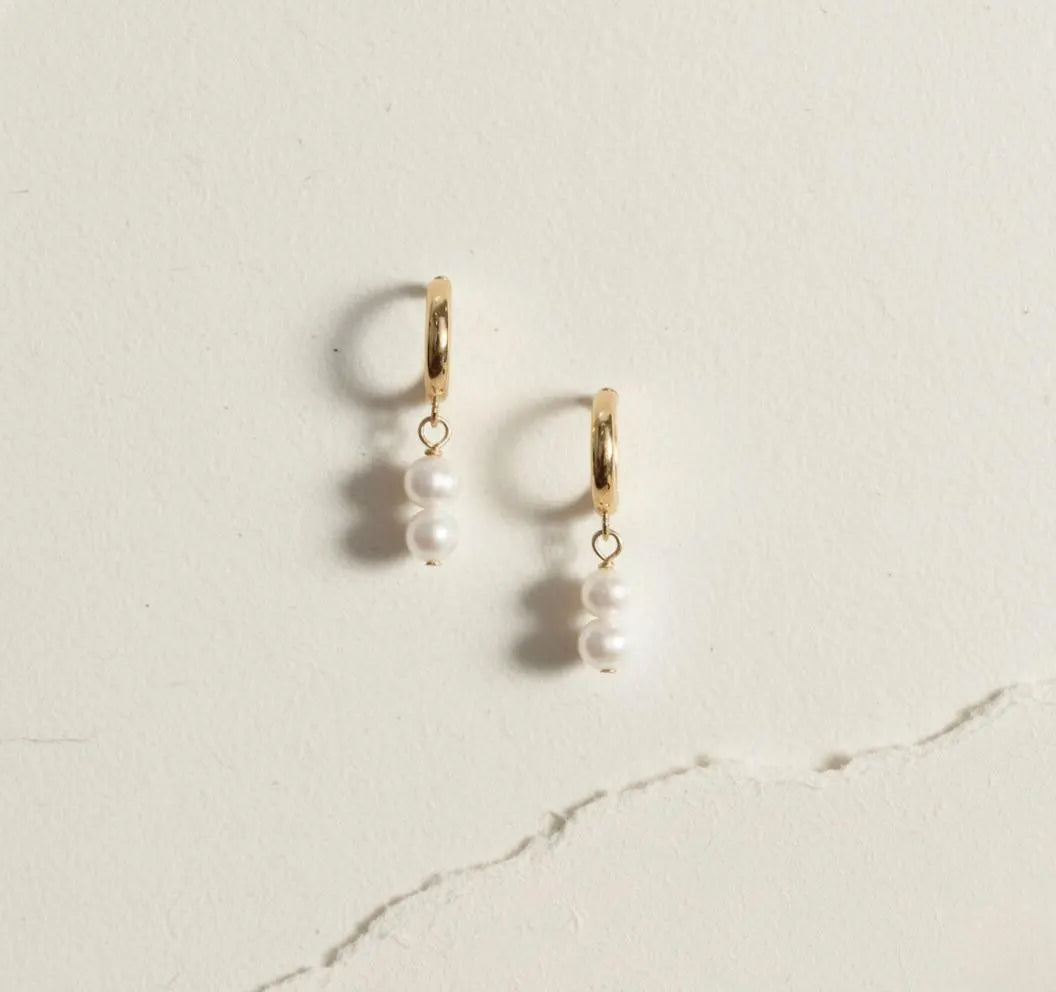 Gold pearl drop hoop earrings with double pearl dangle worn on ear, minimalist waterproof bridal jewelry