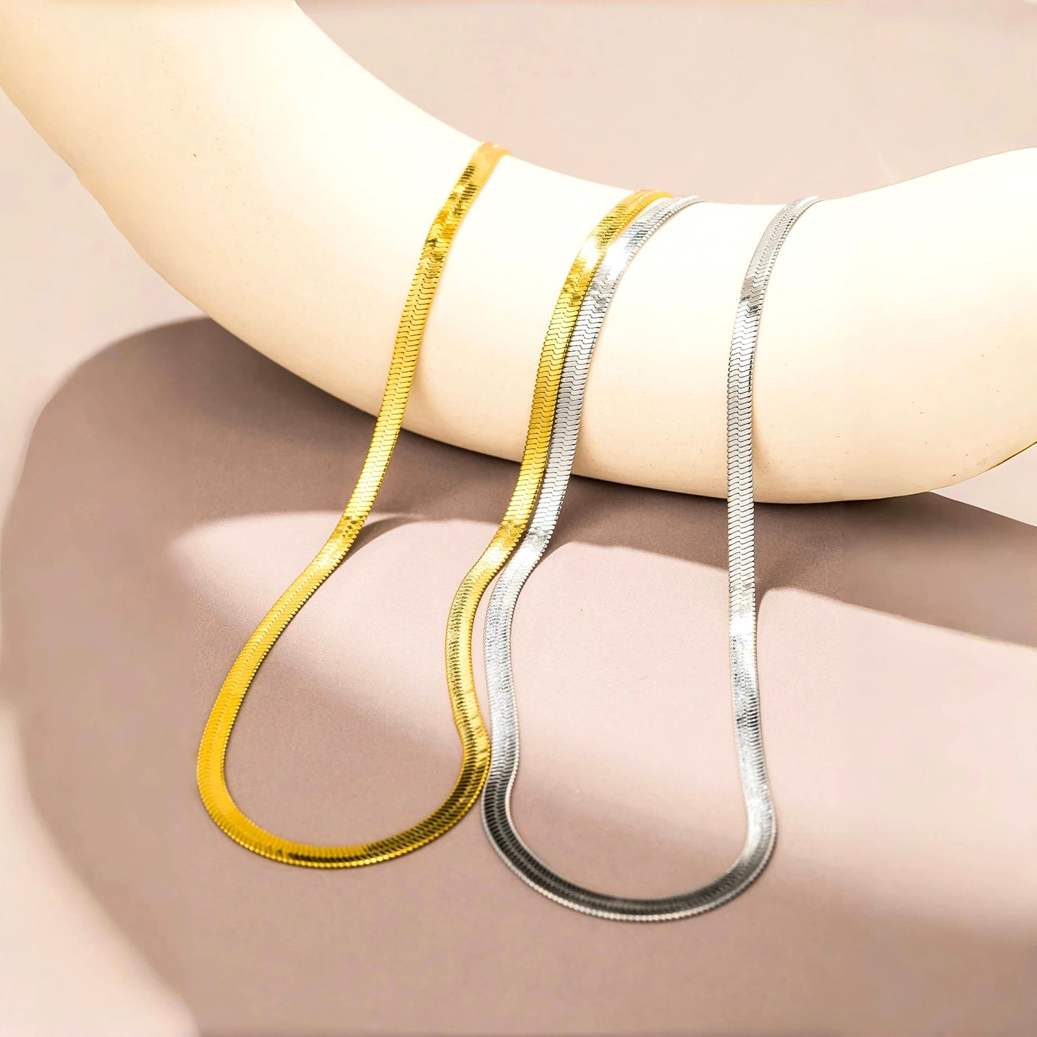 Gold and silver stainless steel snake chain necklaces on display