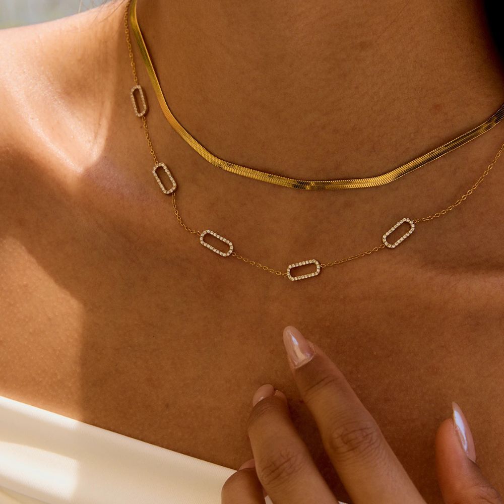 Gold herringbone chain necklace close-up on skin