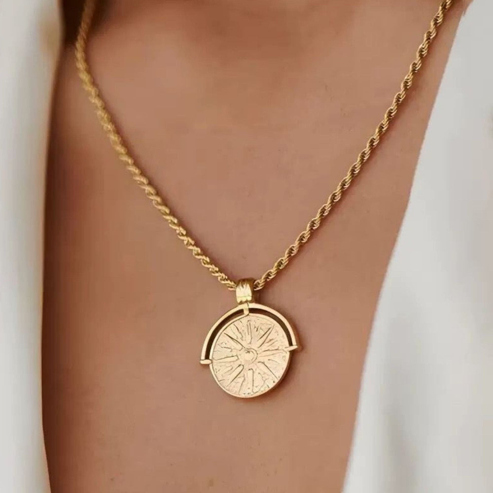 Close-up of the Helia Necklace in gold with detailed sun medallion pendant.