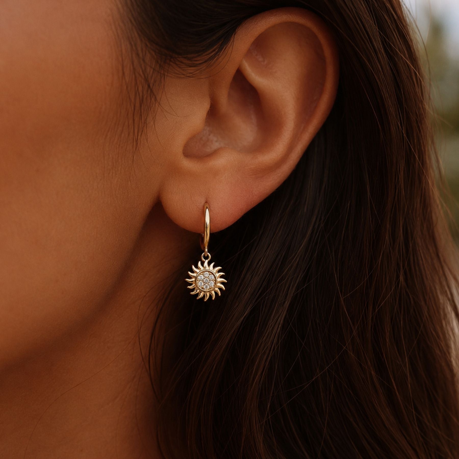 Helio gold sun hoop earrings with sparkling zirconia charm worn on model