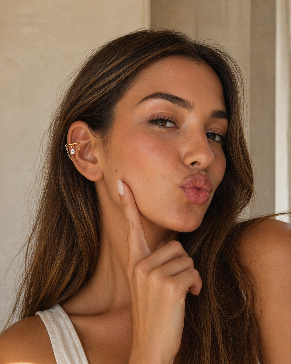 Woman wearing gold helix chain earring with teardrop CZ charm, elegant ear cuff piercing jewelry on helix
