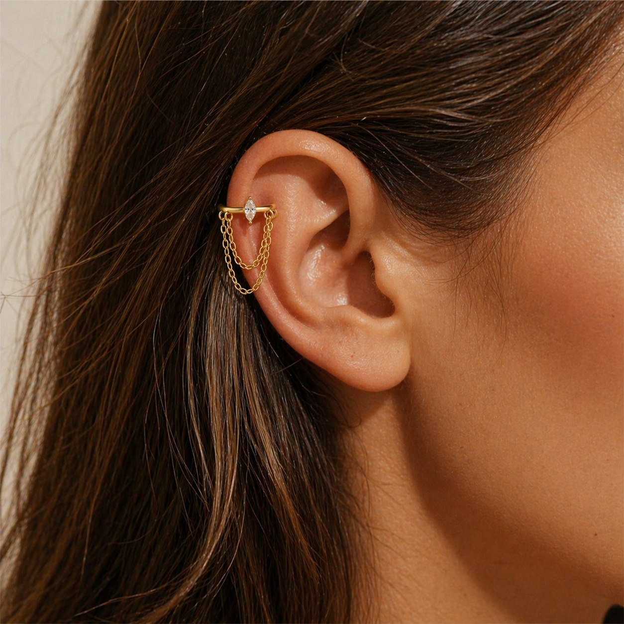 Gold helix chain earring with marquise cubic zirconia stone and double chain detail worn on helix piercing
