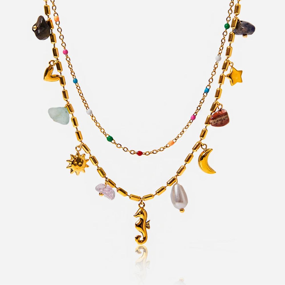 Layered gold charm necklace with beads on white background, summer jewelry flat lay