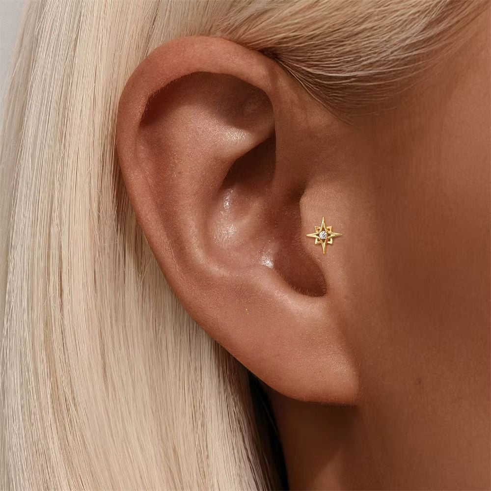 Nova Stud gold star earring worn on tragus cartilage piercing