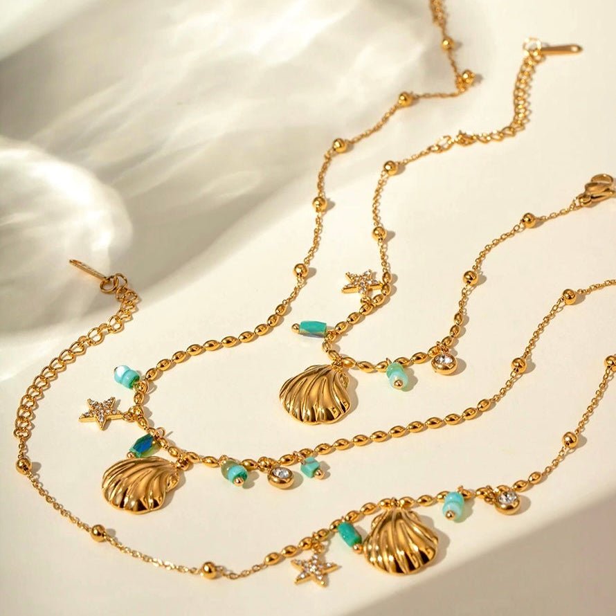 Gold shell necklace and bracelet with turquoise and pearl details inspired by the sea