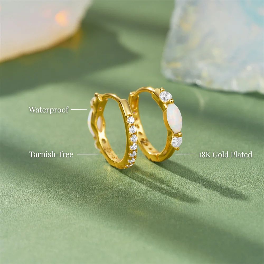 Gold plated opal hoop earrings pair displayed on soft green background