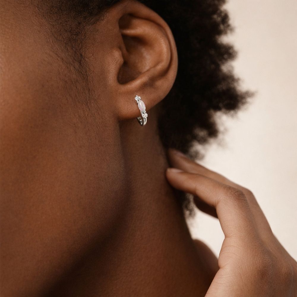 Model wearing silver 925 sterling silver opal huggie hoop earrings