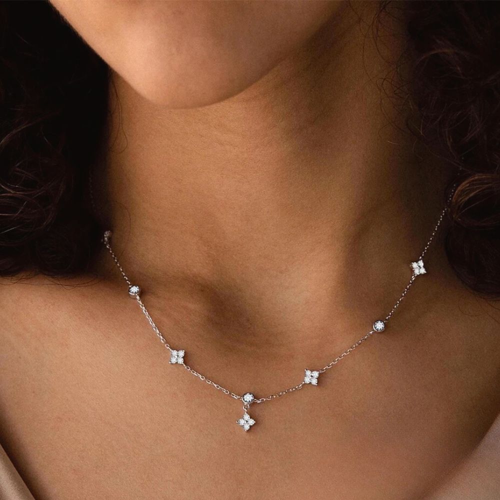 Close-up of silver daisy diamond station necklace featuring diamond zircon flower charms
