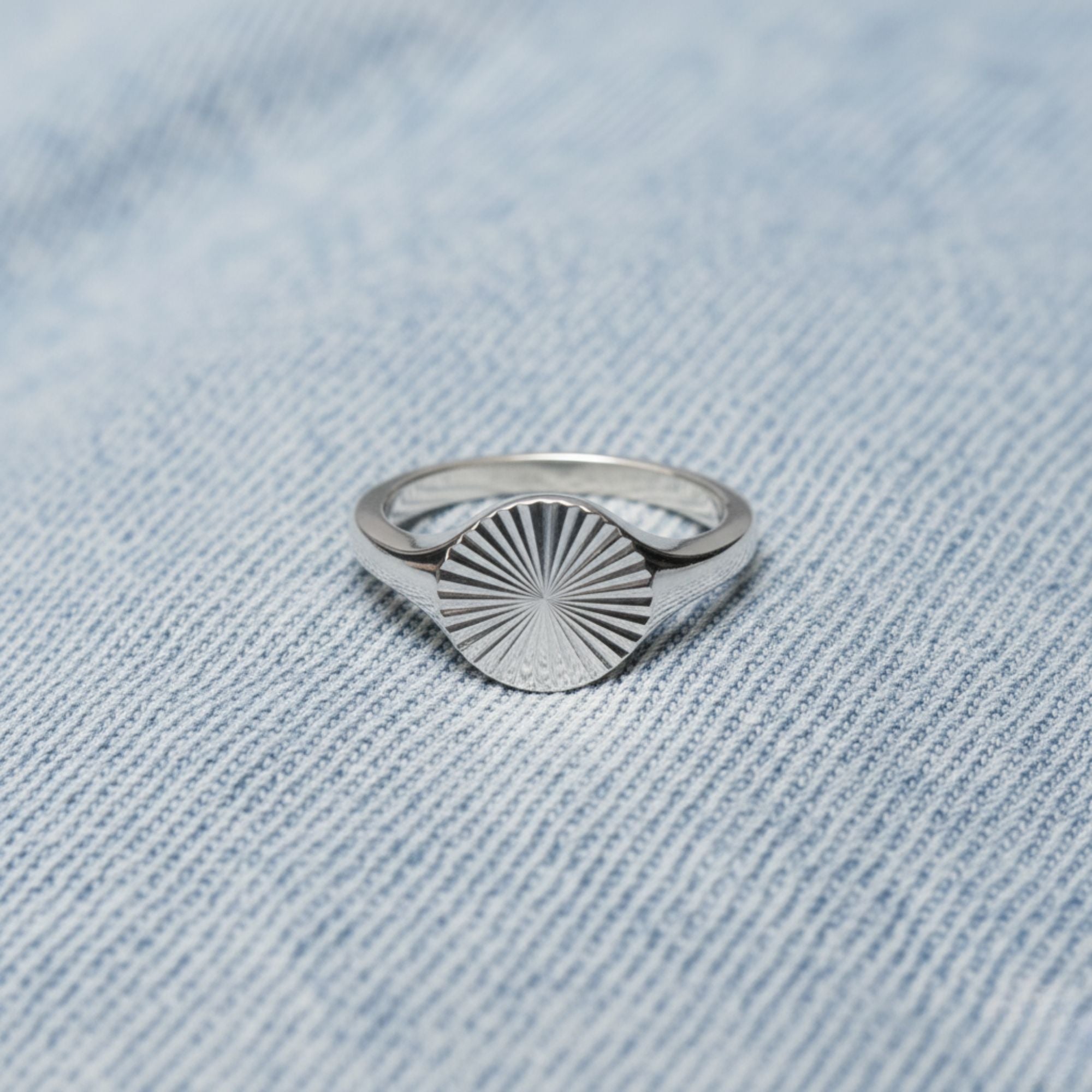 Silver Sunbeam Signet Ring on light blue denim background – waterproof stainless steel jewelry by Beach Bloom Jewelry.