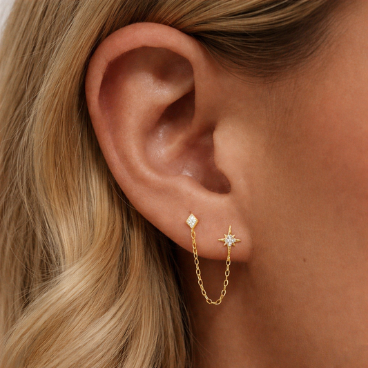 Starfall Stud double piercing chain earring worn on two lobe piercings with gold chain connecting studs