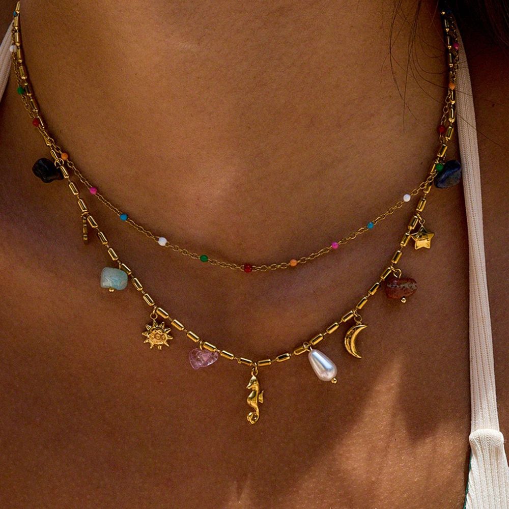 Summer layered gold charm necklace worn on model with bikini, beach jewelry
