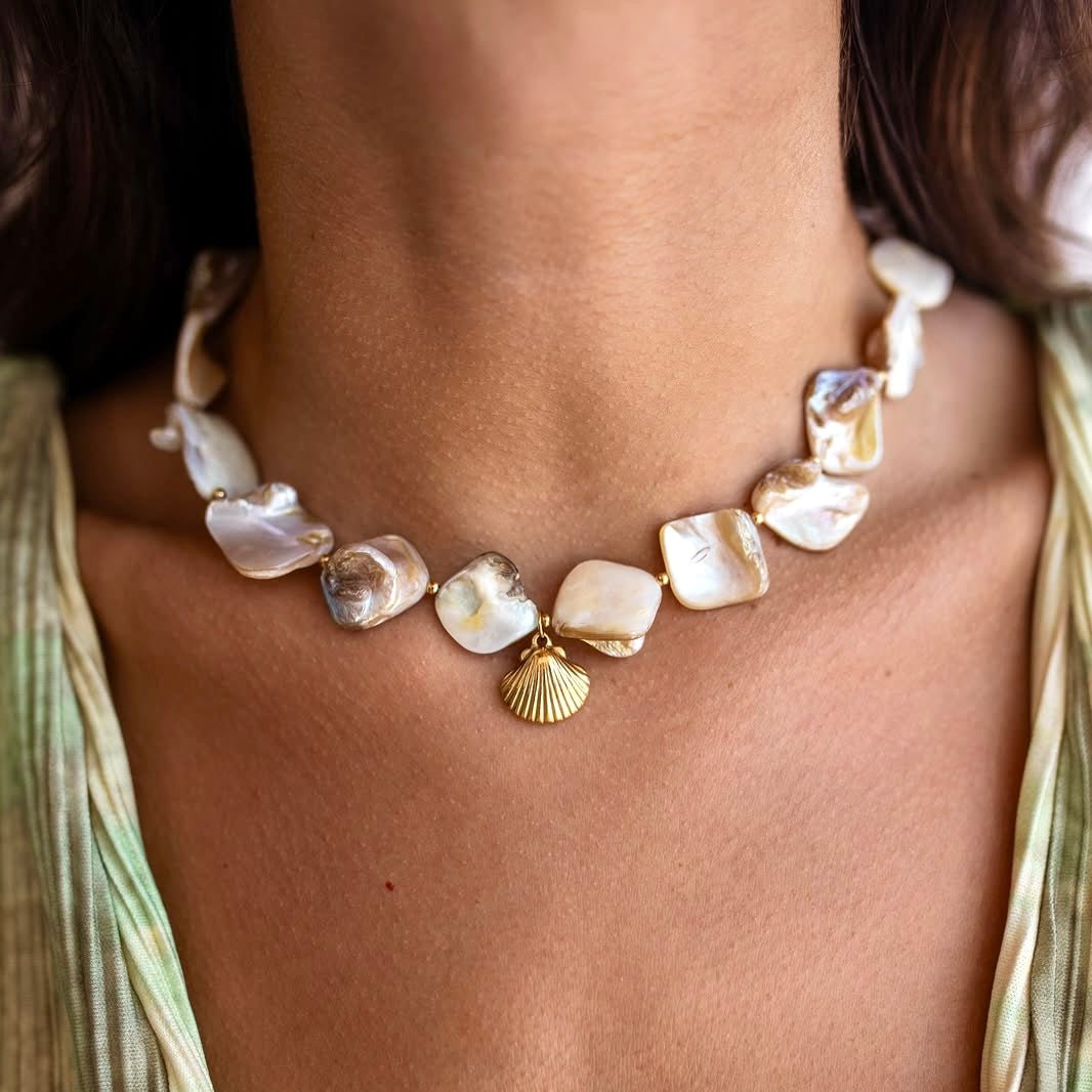 Waterproof gold bracelet with shell charm worn under sunlight