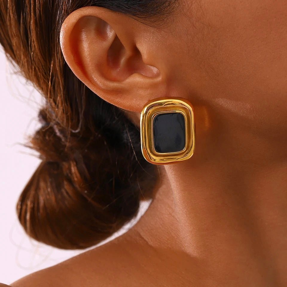 Woman wearing vintage gold and black rectangular earrings