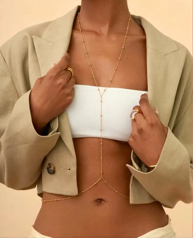 Minimalist gold stainless steel waist chain worn over a crop top and blazer – elegant and adjustable body jewelry
