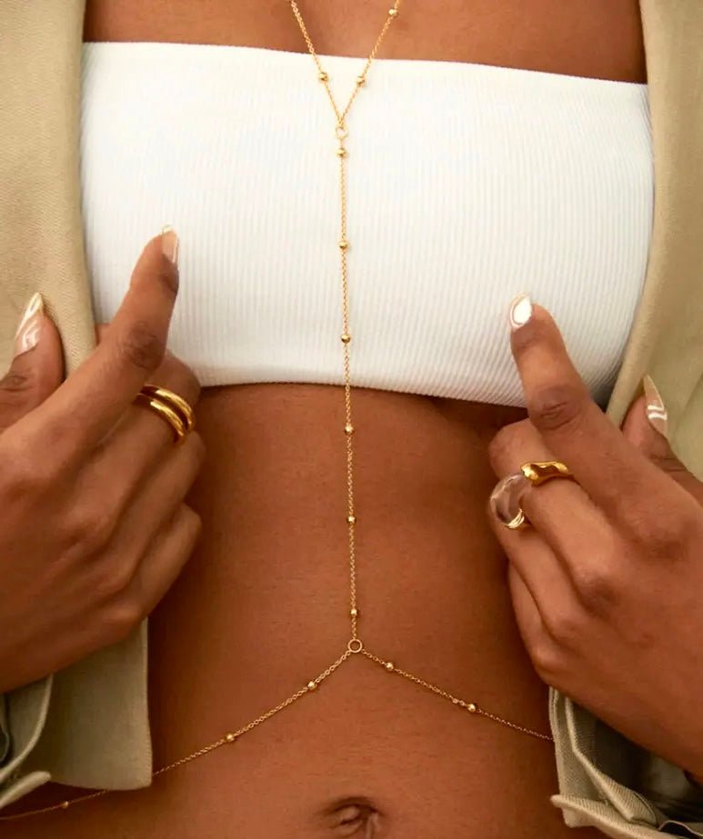 Minimalist gold stainless steel waist chain worn over a crop top and blazer – elegant and adjustable body jewelry